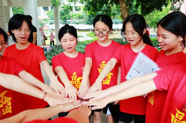 高考首日，玉林市第十中學(xué)的高三教師們列隊為考生們加油鼓勁，現(xiàn)場氛圍熱烈。（圖：侯杰 文：李澤瑞）.jpg