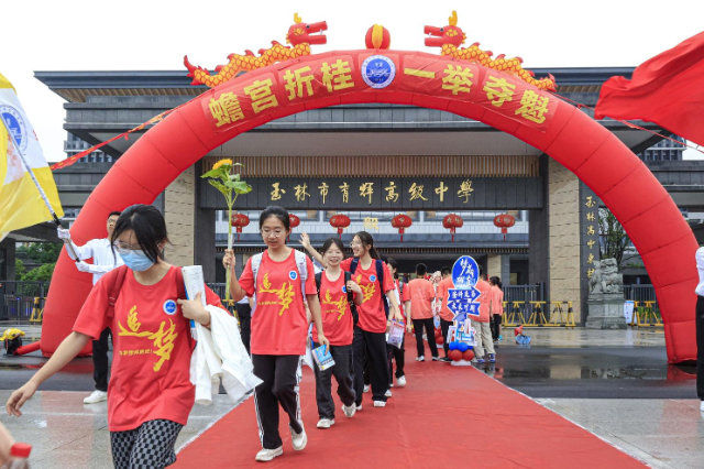 玉林市育輝高級中學(xué)紅毯鋪地，紅聯(lián)掛樓，為勇士出征高考助威祝福。在一片助威聲中，育園學(xué)子目光如炬，步伐堅定，意氣風(fēng)發(fā)地邁過狀元門，斗志昂揚(yáng)地出征高考。（陳穎強(qiáng)  周家名）.png