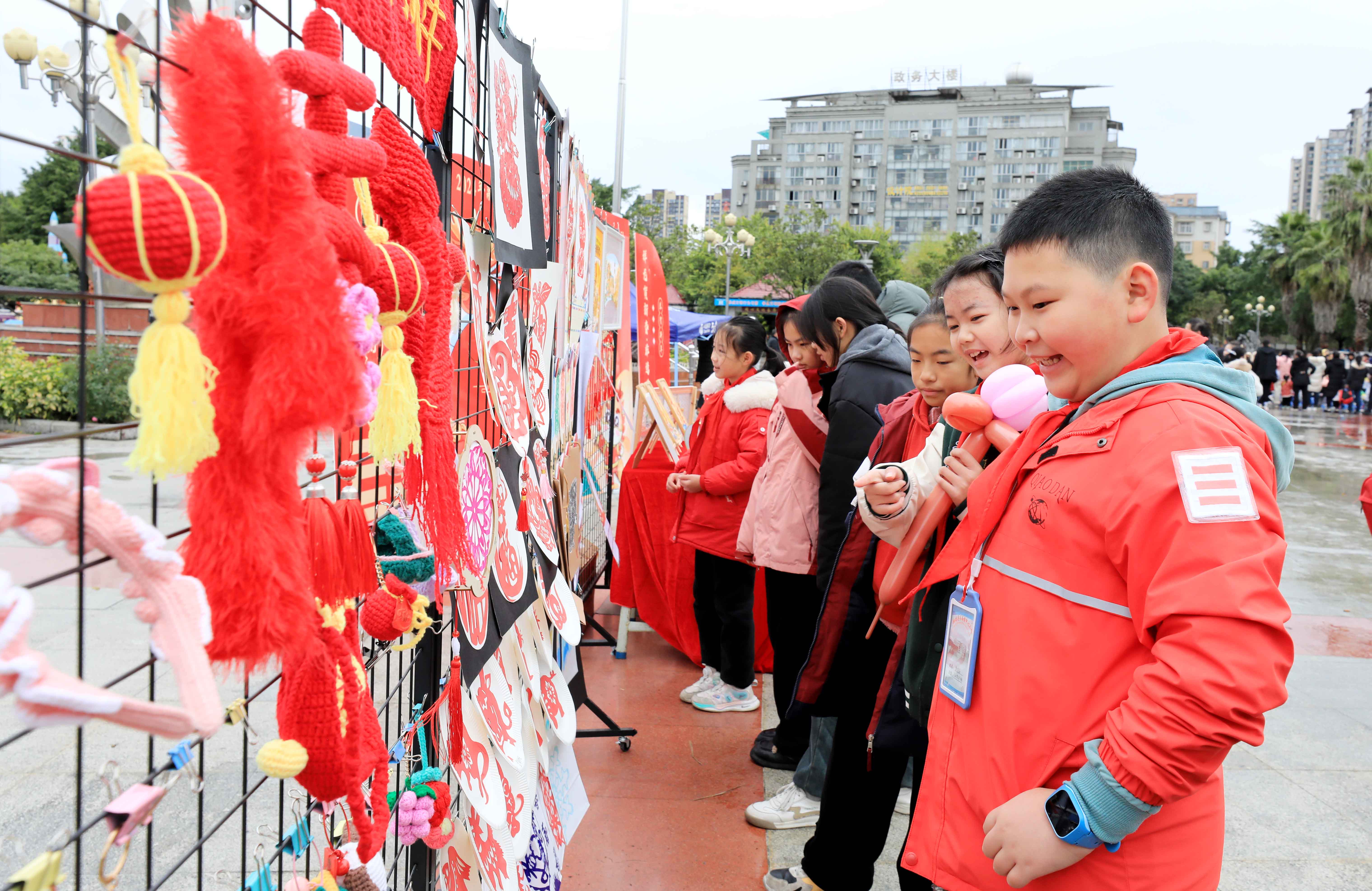 圖7：1月20日，在廣西柳州市融安縣長(zhǎng)安廣場(chǎng)，學(xué)生在非遺集市上選購(gòu)作品。（譚凱興 攝）.JPG